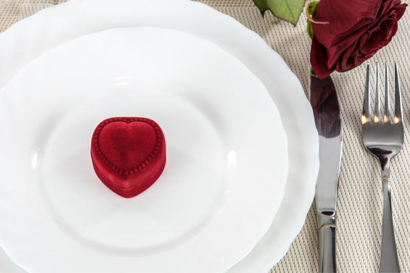 romantic restaurant with plate, rose, and ring